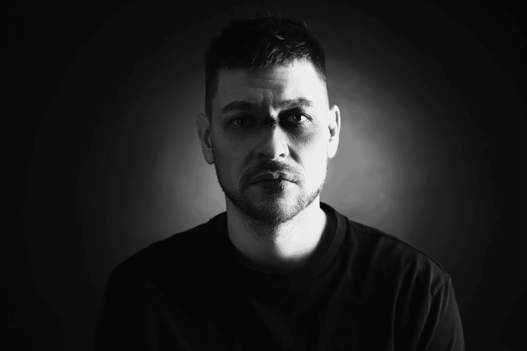 Steve, moody black and white portrait of a serious young man with intense expression and short hair, emphasizing emotional depth and introspection.