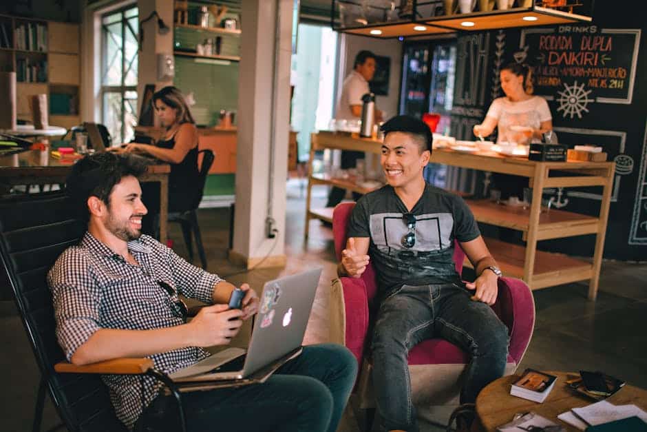People socializing and working in a modern coffee shop interior casual ambiance with laptops and smartphones at The Solemn Sir.