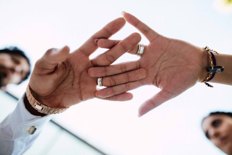 Close-up of two hands with rings touching, symbolizing love and commitment.