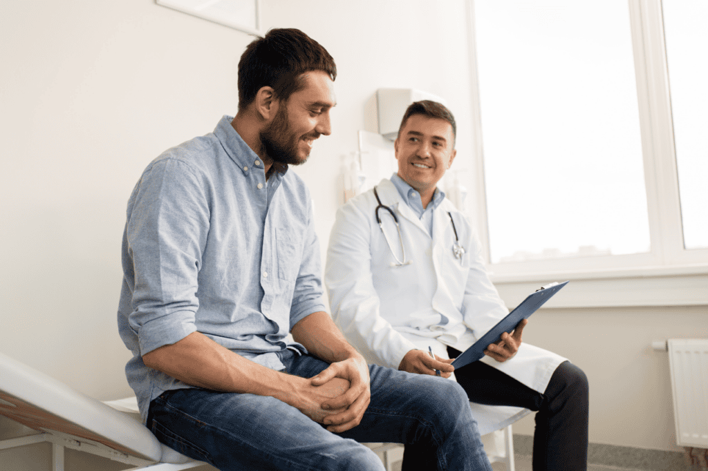 Young male patient consulting with a doctor during a medical check-up at a clinic, healthcare, health assessment, doctor-patient interacting, medical exam, clinic visit, professional healthcare services.