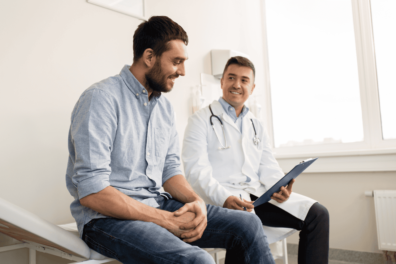 Young male patient consulting with a doctor during a medical check-up at a clinic, healthcare, health assessment, doctor-patient interacting, medical exam, clinic visit, professional healthcare services.