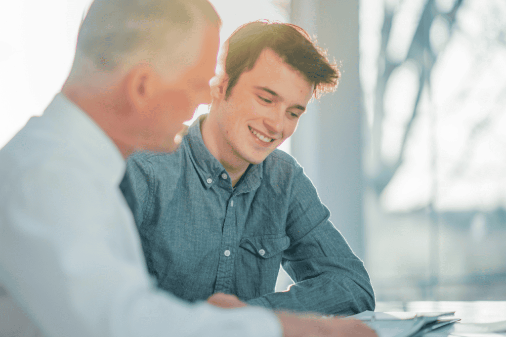 Professional young man smiling during business meeting in modern office environment.