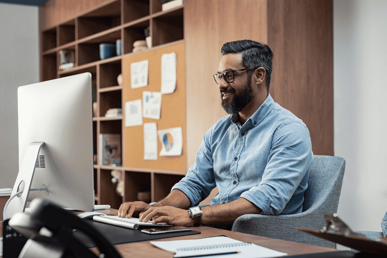 Professional man working at office computer, smiling and typing, modern workspace, business professional, corporate environment, desk with documents, creative professional, The Solemn Sir.