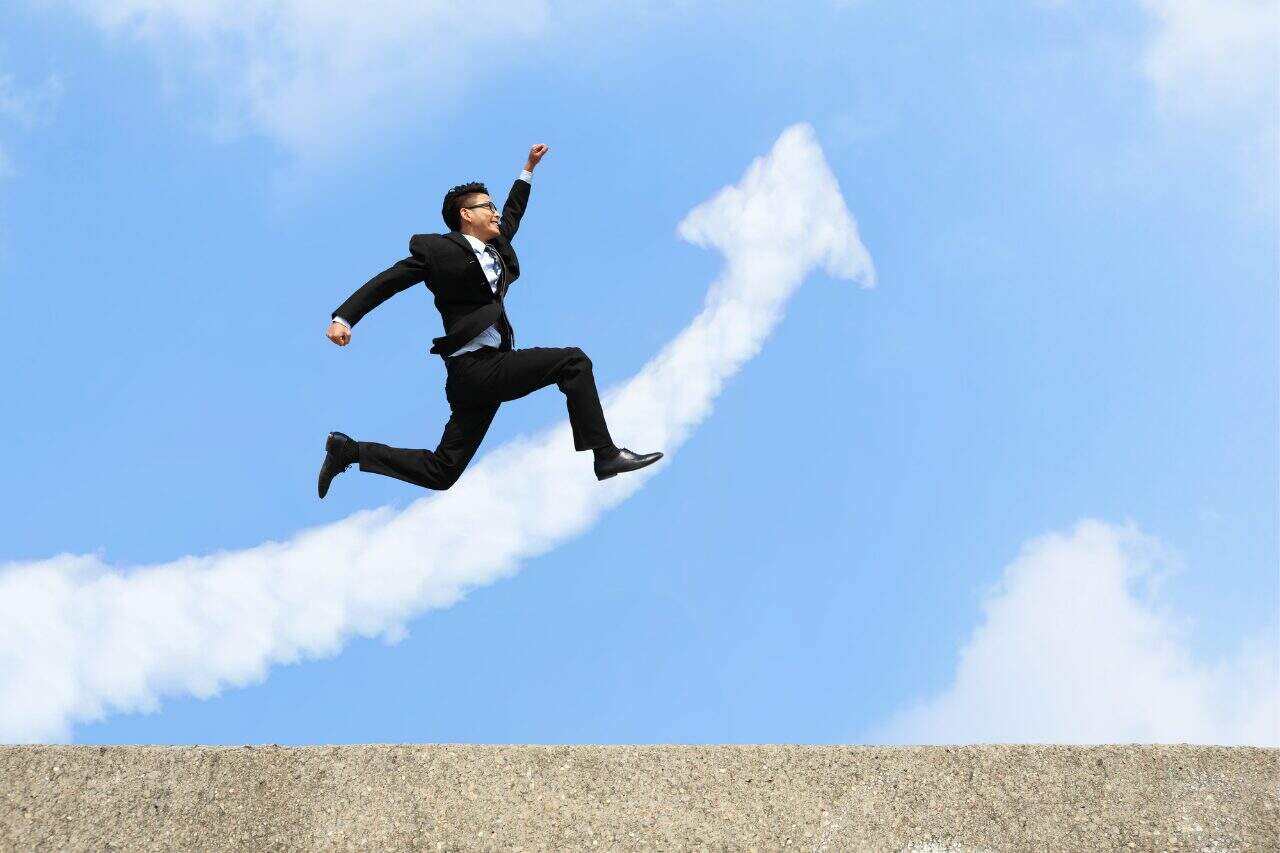 Jumping businessman in suit with New York City skyline background success and career growth imagery.