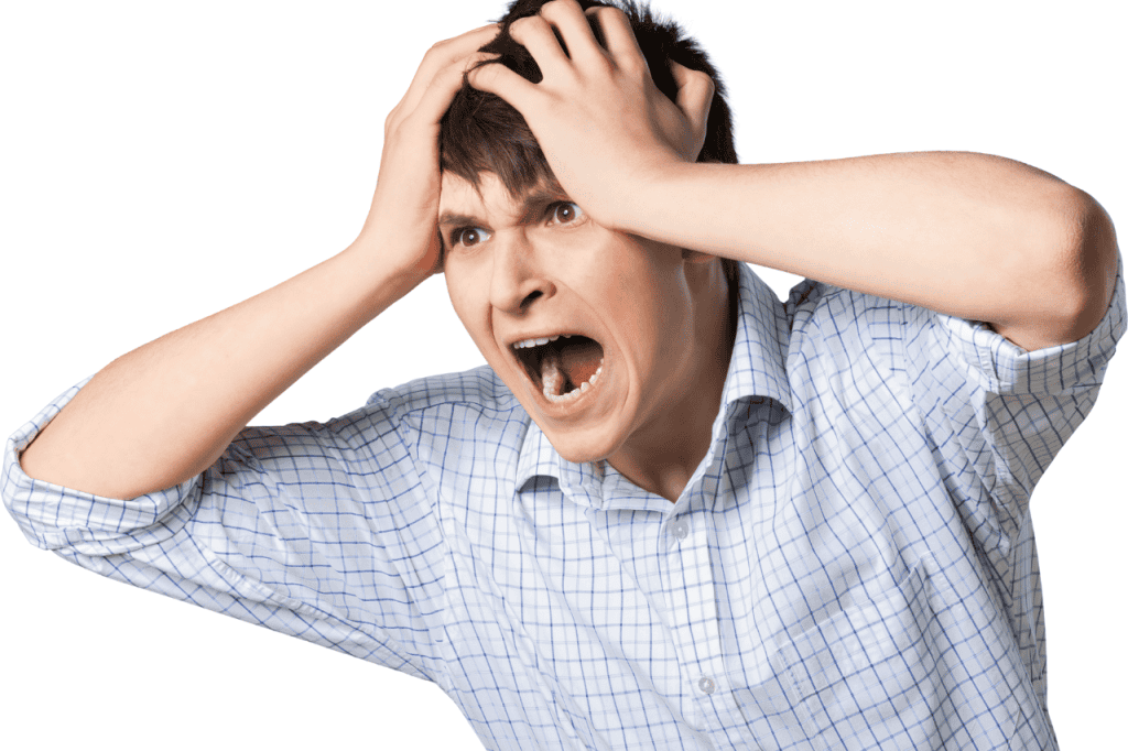 Frustrated man holding head, expressing stress or anxiety, wearing a checkered shirt, isolated on white background, representing mental health struggles, emotional distress, or life challenges.