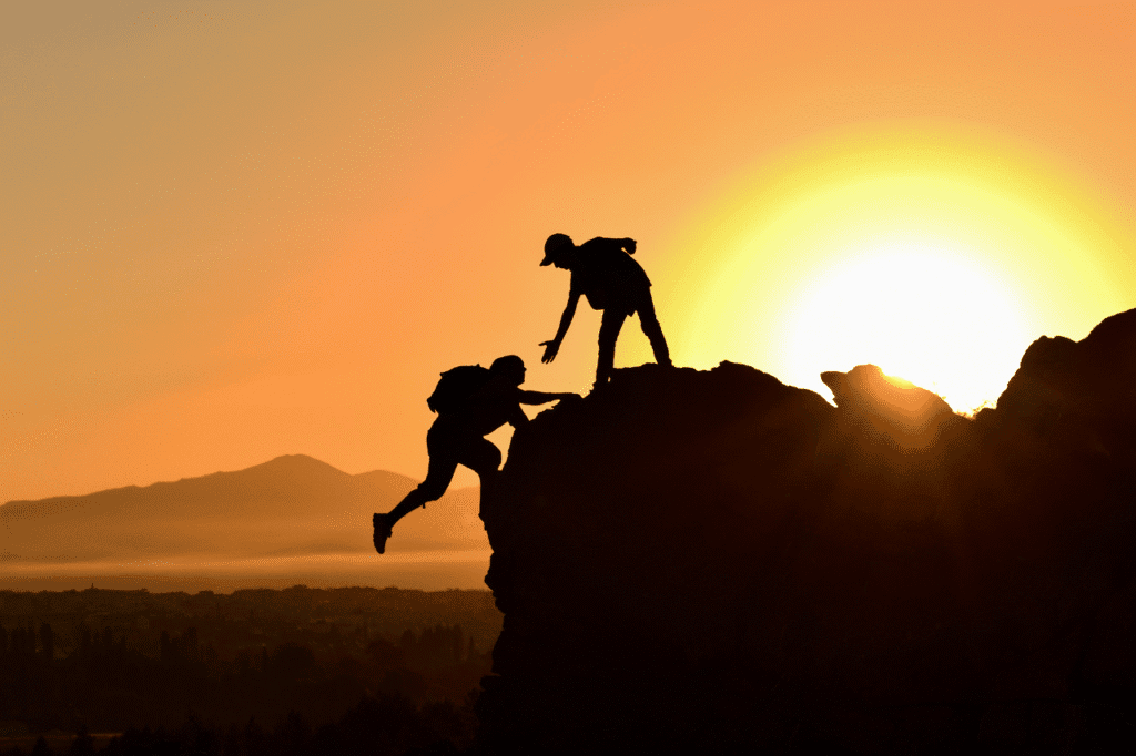 Climbing mountain rescue teamwork sunset silhouette adventure perseverance teamwork effort.